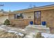 Front entrance with blue pots, brick facade, and a security door at 7023 S Buffalo St, Littleton, CO 80120