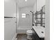 Updated bathroom featuring white marble tile, shower and tub combo, and black fixtures at 4232 S Grant St, Englewood, CO 80113