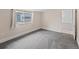 Bright bedroom featuring neutral walls, soft gray carpet, and a large window for natural light at 4232 S Grant St, Englewood, CO 80113
