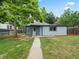 Exterior view of home with a grass lawn and mature tree at 4232 S Grant St, Englewood, CO 80113