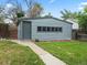 Detached garage with gray siding, a pedestrian door, and window accents at 4232 S Grant St, Englewood, CO 80113