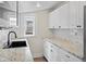 Bright kitchen featuring granite counters, white cabinets and hardware, and a black sink at 4232 S Grant St, Englewood, CO 80113