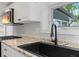 Bright kitchen featuring granite counters, stainless appliances, and black sink and hardware at 4232 S Grant St, Englewood, CO 80113