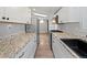 Galley-style kitchen features granite counters, stainless steel appliances, and hardwood flooring at 4232 S Grant St, Englewood, CO 80113