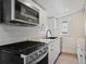 Modern kitchen boasts stainless appliances, a black sink, and an exhaust fan over the stove at 4232 S Grant St, Englewood, CO 80113