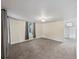 Spacious living area with neutral carpet and paint, plus a glimpse into the kitchen and hallway at 4232 S Grant St, Englewood, CO 80113