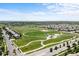 An aerial view of a suburban community featuring homes near a baseball field, playground, and walking paths at 15602 E 117Th Ave, Commerce City, CO 80022
