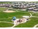 An aerial perspective of homes neighboring a spacious park with baseball diamonds and a playground at 15602 E 117Th Ave, Commerce City, CO 80022