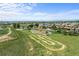 An aerial shot of a suburban neighborhood with a large park including a playground and bike track at 15602 E 117Th Ave, Commerce City, CO 80022