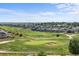 A scenic view of a golf course community with homes backing onto lush fairways and green spaces at 15602 E 117Th Ave, Commerce City, CO 80022