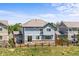 Pretty two-story blue house with a fenced yard, patio, and sliding doors surrounded by green grass and trees at 15602 E 117Th Ave, Commerce City, CO 80022
