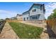 Backyard with a spacious lawn, rock perimeter, wood fence and a view of the home at 15602 E 117Th Ave, Commerce City, CO 80022