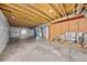 Unfinished basement featuring concrete floor, exposed beams, and utilities with a window for natural light at 15602 E 117Th Ave, Commerce City, CO 80022