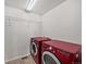 A modern laundry room featuring red front-load washer and dryer set, and wire shelving above at 15602 E 117Th Ave, Commerce City, CO 80022