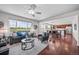 Bright open-concept living room with hardwood floors, modern furnishings, and a kitchen view at 15602 E 117Th Ave, Commerce City, CO 80022