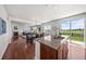 Modern open floorplan featuring a kitchen island, dining area, and living space with abundant natural light at 15602 E 117Th Ave, Commerce City, CO 80022