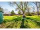 Large backyard with a well-maintained lawn, mature trees, and a wooden fence at 1542 Kilkenny, Boulder, CO 80303