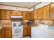 Well-lit kitchen featuring tile countertops, lots of cabinets, and standard white appliances at 1542 Kilkenny, Boulder, CO 80303