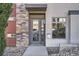 Modern home entrance featuring a gray door, stone accents, and house number against a neutral facade at 3361 Mariposa St, Denver, CO 80211