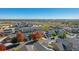 Aerial view of neighborhood with autumn trees and a school at 889 Crest St, Lochbuie, CO 80603