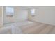 Bright bedroom with neutral carpet and two windows at 889 Crest St, Lochbuie, CO 80603