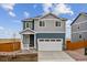 Two-story home with gray siding, white trim, and a two-car garage at 889 Crest St, Lochbuie, CO 80603