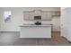 Modern kitchen with island, stainless steel appliances, and gray cabinets at 889 Crest St, Lochbuie, CO 80603