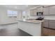 Modern kitchen with island, stainless steel appliances, and gray cabinets at 889 Crest St, Lochbuie, CO 80603