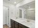 Modern bathroom with double vanity, dark wood cabinets, and a large mirror, offering a clean, efficient space at 14536 Mellow Ct, Morrison, CO 80465