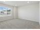 Bright bedroom with large window and neutral carpet, providing a serene space with plenty of natural light at 14536 Mellow Ct, Morrison, CO 80465
