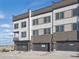 Modern townhome exterior featuring a multi-tone facade, private garages, and manicured landscaping at 14536 Mellow Ct, Morrison, CO 80465
