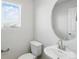 Powder room featuring a pedestal sink, oval mirror, and window at 14536 Mellow Ct, Morrison, CO 80465