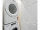 Efficient laundry area with stacked white washer and dryer, maximizing space in a compact, easily accessible location at 14536 Mellow Ct, Morrison, CO 80465