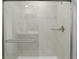 Elegant shower showcasing large neutral tiles, glass doors, and modern fixtures, providing a spa-like experience at 14536 Mellow Ct, Morrison, CO 80465