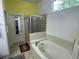 Bright bathroom features a soaking tub, glass enclosed shower, and a window for natural light at 9798 Grove St, Westminster, CO 80031