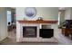 Living room showcasing fireplace with decorative mantel and views to the kitchen and adjacent living spaces at 9798 Grove St, Westminster, CO 80031