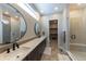 Modern bathroom featuring dual sinks, a walk-in shower, and a stylish, elongated vanity at 6759 Canyonpoint Rd, Castle Pines, CO 80108