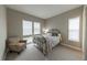 Cozy bedroom with neutral tones, a wrought iron bed frame, carpet and bright natural light from three windows at 6759 Canyonpoint Rd, Castle Pines, CO 80108
