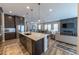 Open-concept kitchen and living room with stainless appliances and adjacent fireplace at 6759 Canyonpoint Rd, Castle Pines, CO 80108