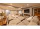 An enormous sectional sofa and a fireplace are the focal points of this basement living room at 6759 Canyonpoint Rd, Castle Pines, CO 80108