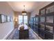 Bright office with a large wooden desk, black bookcase, and neutral decor creating a calm and productive workspace at 6759 Canyonpoint Rd, Castle Pines, CO 80108