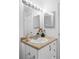 Bright bathroom features a vanity with neutral counters, white cabinets, and a large, well-lit mirror at 8787 Yukon St, Arvada, CO 80005