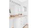 Bright bathroom features a vanity with neutral counters, white cabinets, and a large, well-lit mirror at 8787 Yukon St, Arvada, CO 80005