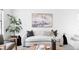 Bright living room features a neutral sofa, modern art, and a tall plant next to a window at 8787 Yukon St, Arvada, CO 80005
