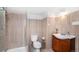 Updated bathroom featuring a walk-in shower, and a cherry vanity, and light tan tiled walls at 1608 Beaver Brook Canyon Rd, Evergreen, CO 80439