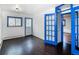 Bedroom showcasing hardwood flooring, white walls, neutral tones, and a bright blue door at 1608 Beaver Brook Canyon Rd, Evergreen, CO 80439