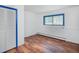 Bright bedroom featuring wood floors, white walls and blue trim window and closet creating a clean, modern look at 1608 Beaver Brook Canyon Rd, Evergreen, CO 80439