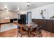 Open dining room area boasting wood floors, accent wall and horse artwork above dark wood cabinets at 1608 Beaver Brook Canyon Rd, Evergreen, CO 80439