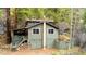 Two-story home featuring green siding, a covered deck, and a stone foundation at 1608 Beaver Brook Canyon Rd, Evergreen, CO 80439