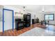 Kitchen featuring wood floors, a black appliance suite, patterned tile backsplash, and blue-framed doorways at 1608 Beaver Brook Canyon Rd, Evergreen, CO 80439